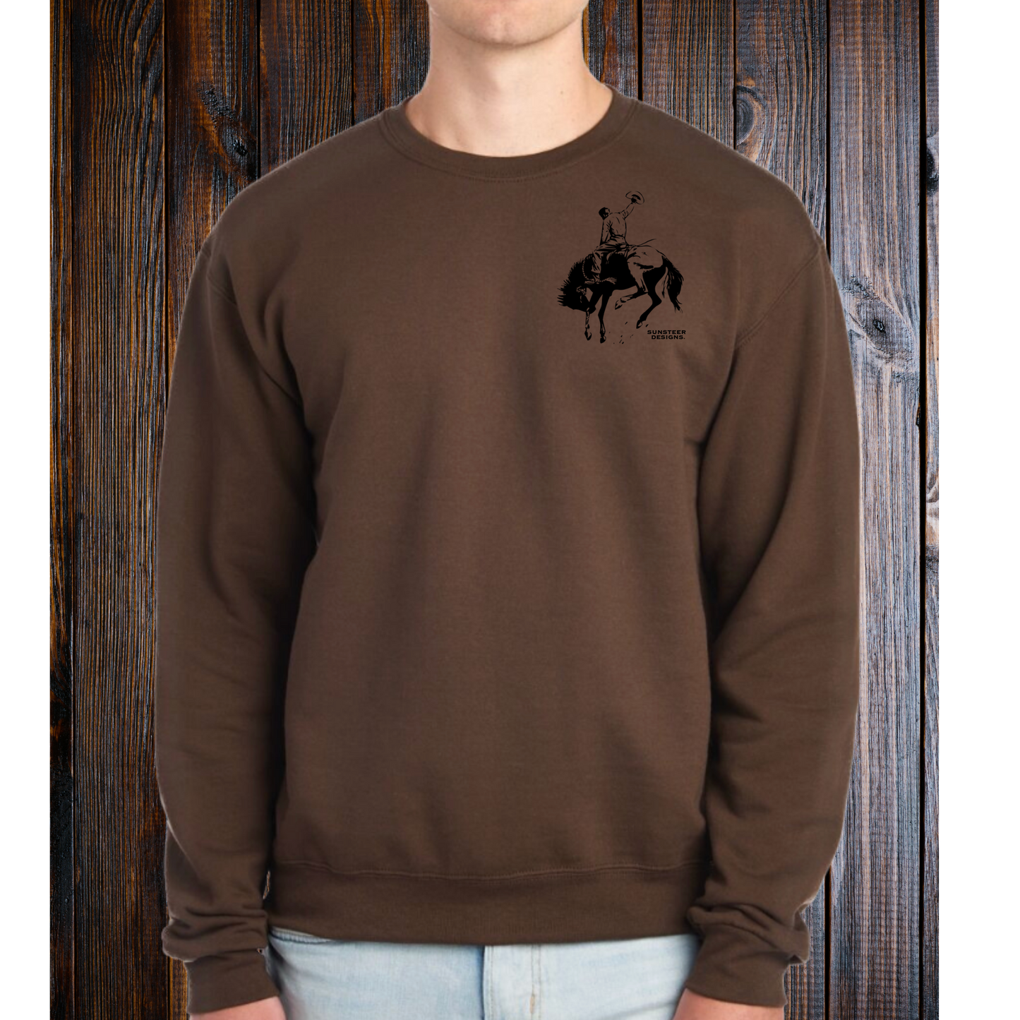 Person wearing a brown sweatshirt with a graphic design on a wooden background