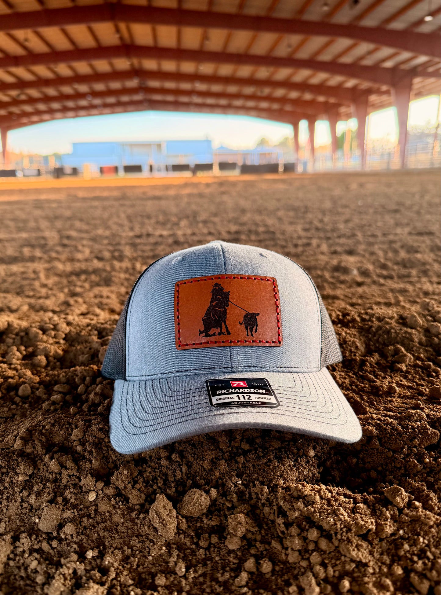 Grey and back cap with breakaway roping design in an arena