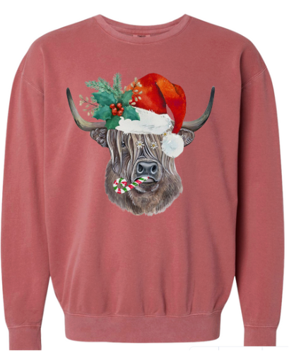 Red sweatshirt with a highland cow wearing a Santa hat and candy cane around its neck on a white background
