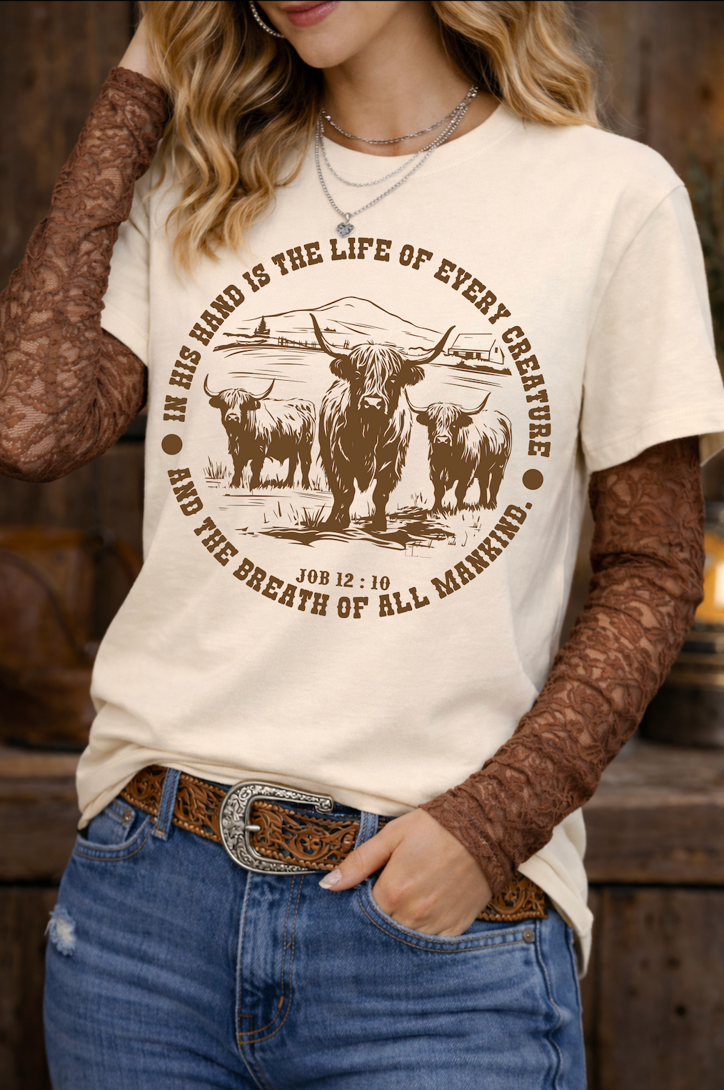 Person wearing a t-shirt with a graphic design and text, standing against a wooden background.