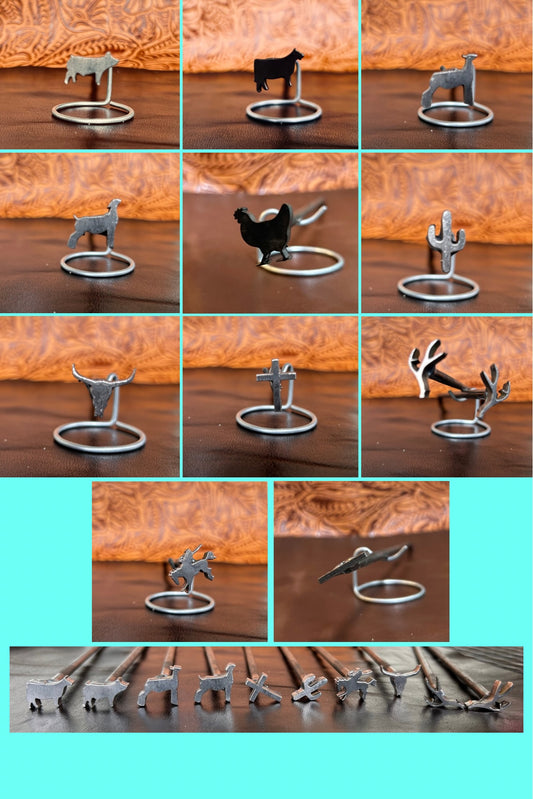 Collection of metal animal figurines on a wooden surface with a teal background.