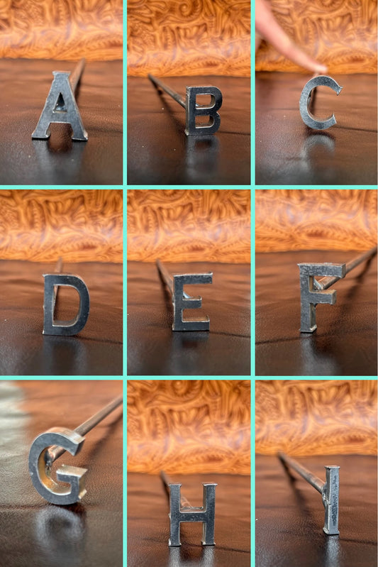 Silver letter hairpins arranged in a grid on a wooden background