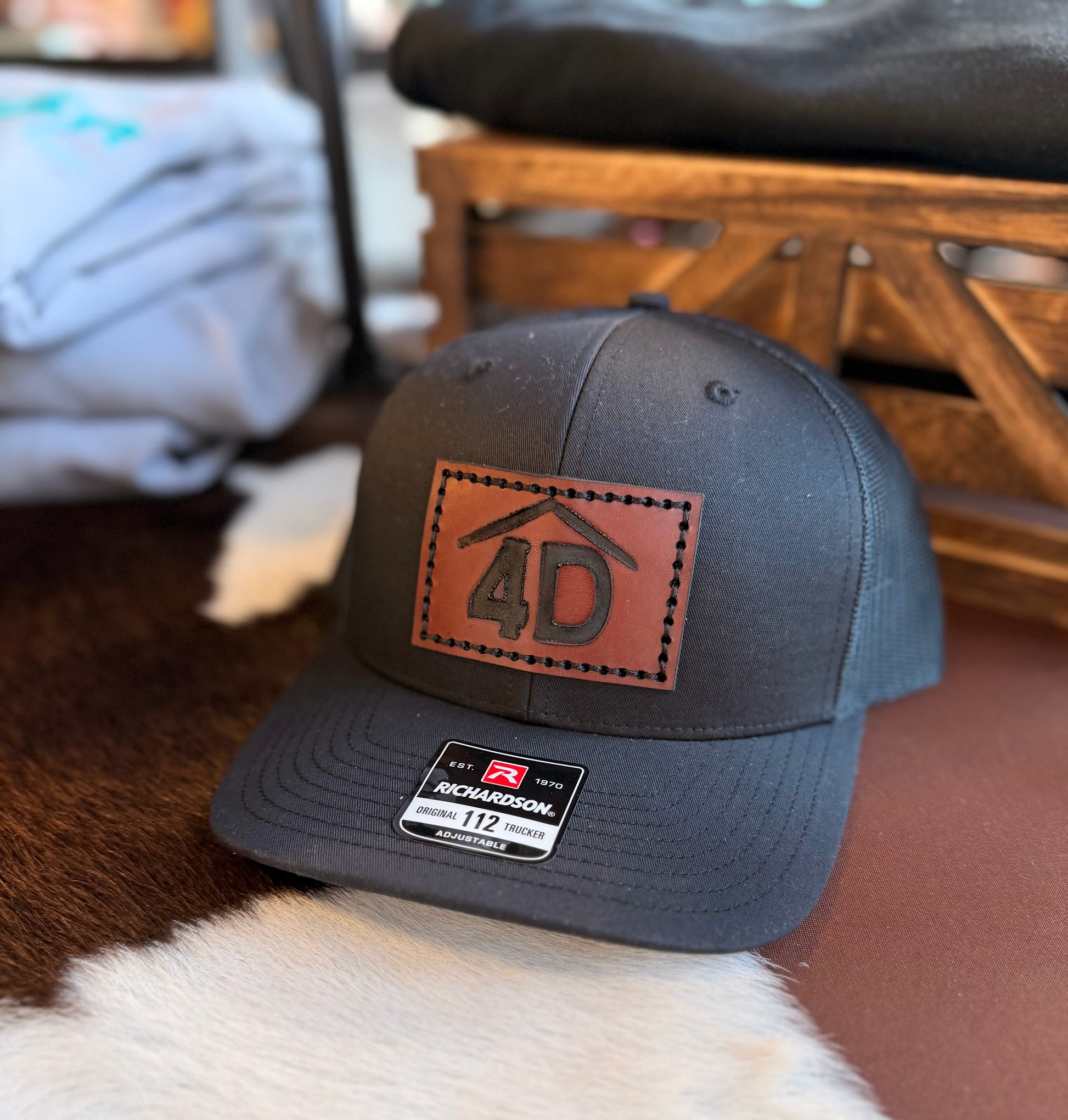 Black cap with a branded brown leather patch featuring the number 4D on a fur surface.