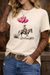 Person wearing a white t-shirt with a graphic of a person on a horse with pink balloons, paired with brown lace sleeves and blue jeans.