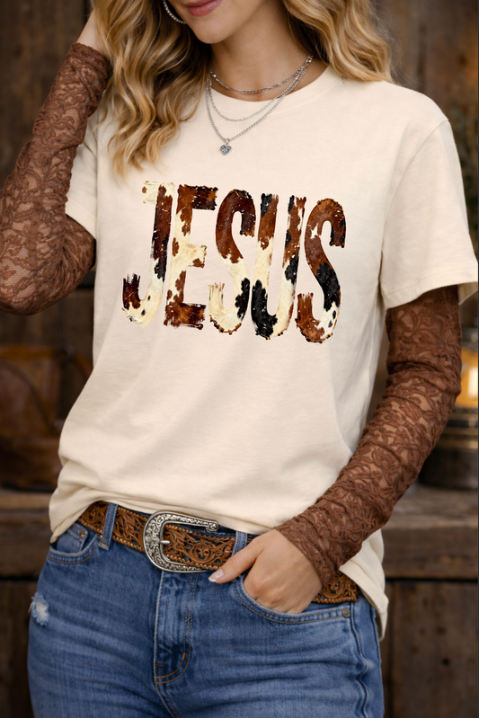 Person wearing a white t-shirt with 'Jesus' printed on it, paired with brown long-sleeve shirts and blue jeans.